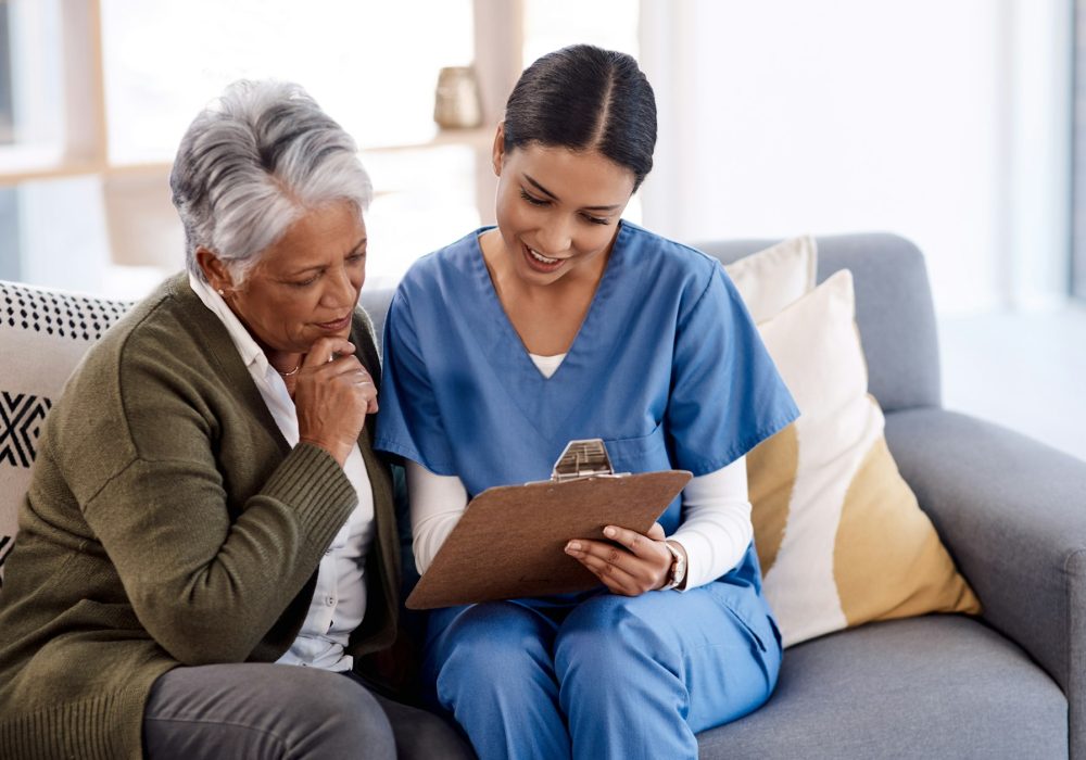 Shot of a young nurse going through paperwork with a senior woman